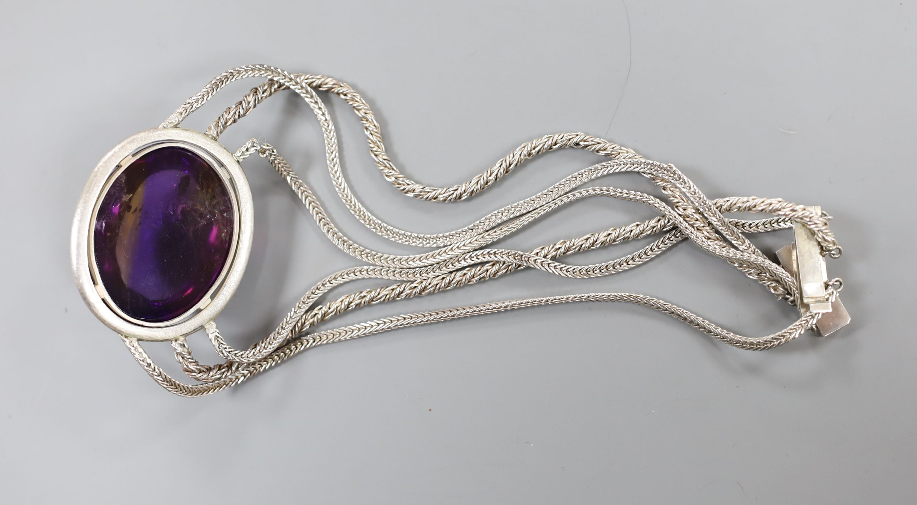 A white metal and large cabochon oval amethyst set triple strand necklace, 47cm